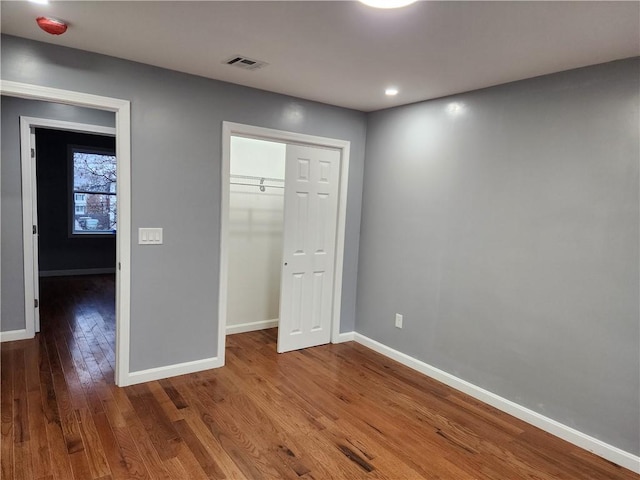 unfurnished bedroom with a closet and wood-type flooring