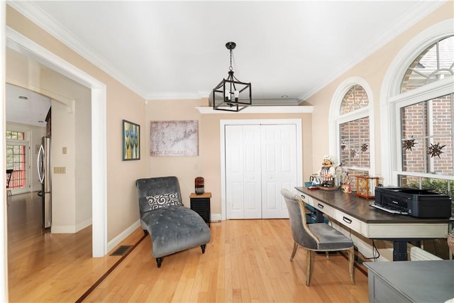 home office with a notable chandelier, light hardwood / wood-style floors, and ornamental molding