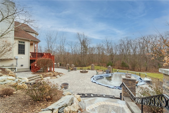 view of patio with a wooden deck and a fire pit