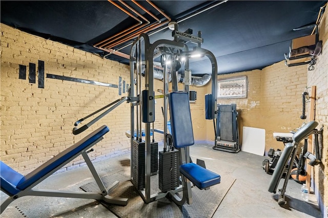 exercise room featuring brick wall