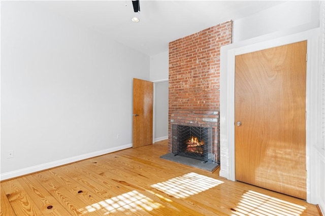 unfurnished living room featuring a fireplace and hardwood / wood-style floors