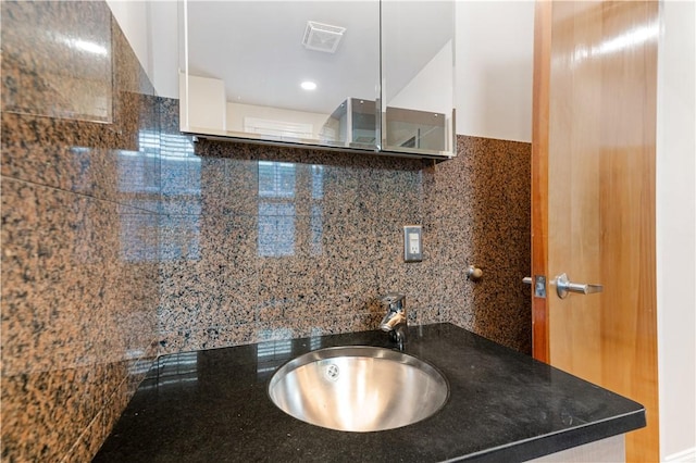 bathroom featuring decorative backsplash and sink