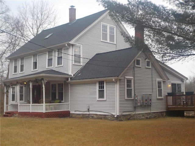 rear view of house with a porch and a yard