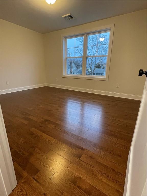 empty room with dark hardwood / wood-style floors