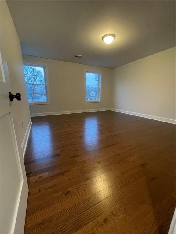 empty room with dark hardwood / wood-style flooring