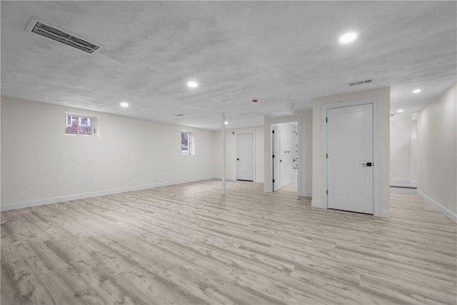 basement with light hardwood / wood-style flooring