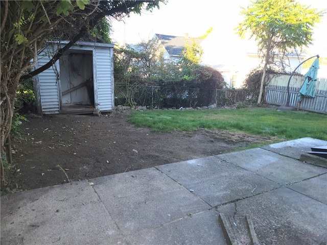 view of yard featuring a storage unit and a patio