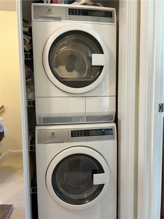 clothes washing area with stacked washer and clothes dryer