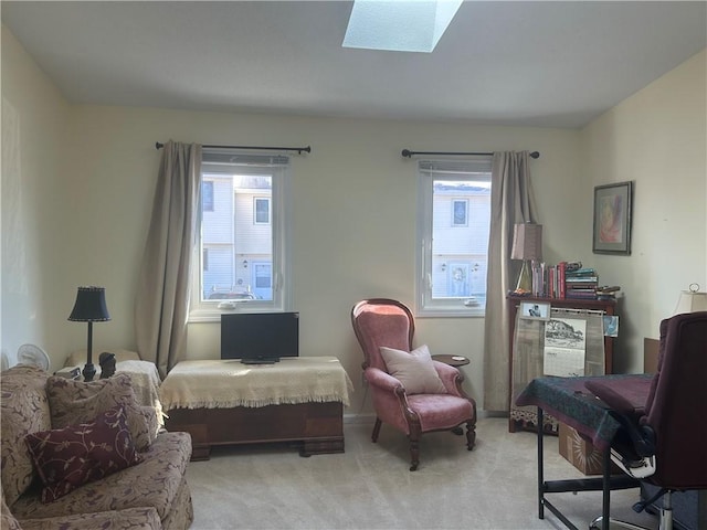 living area featuring light carpet, plenty of natural light, and a skylight