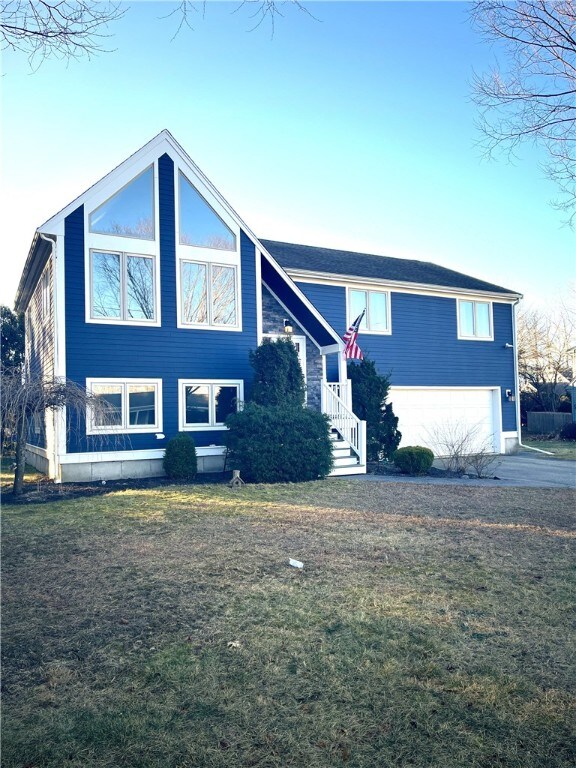 bi-level home with a garage and a front lawn