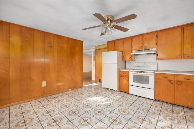 kitchen with white appliances, ceiling fan, and wooden walls