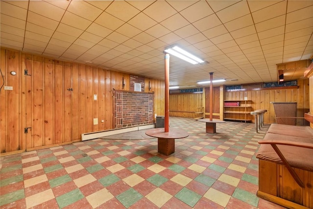 basement featuring baseboard heating and wood walls