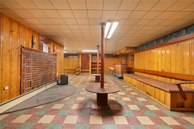 basement featuring baseboard heating and wood walls