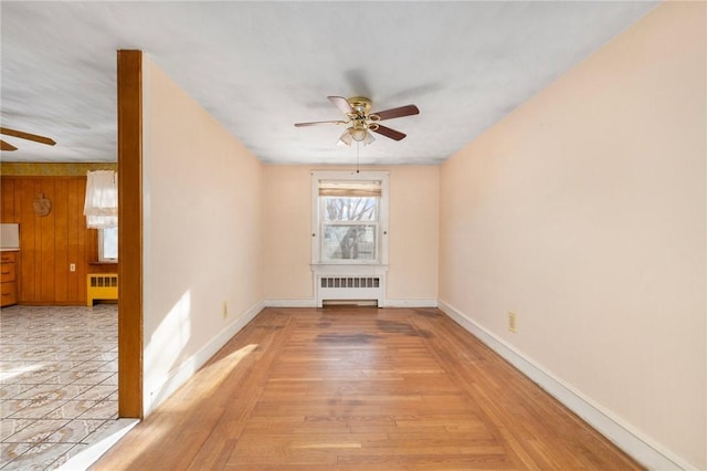 spare room featuring light hardwood / wood-style flooring, radiator, and ceiling fan