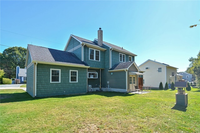 rear view of house with a yard