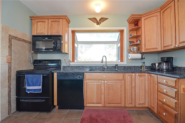 kitchen with black appliances, dark stone countertops, and sink