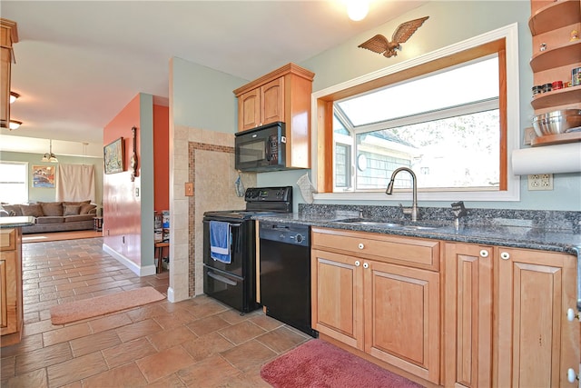 kitchen featuring sink, dark stone counters, and black appliances