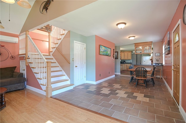 dining area with a wall mounted air conditioner and hardwood / wood-style flooring