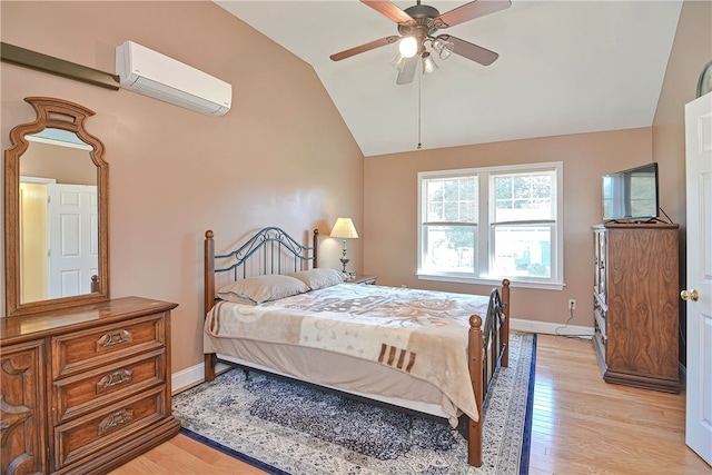 bedroom featuring light wood-type flooring, vaulted ceiling, a wall unit AC, and ceiling fan