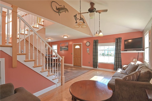 living room with wood-type flooring, lofted ceiling, and a chandelier