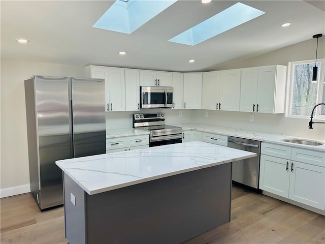 kitchen featuring white cabinets, a center island, sink, and appliances with stainless steel finishes