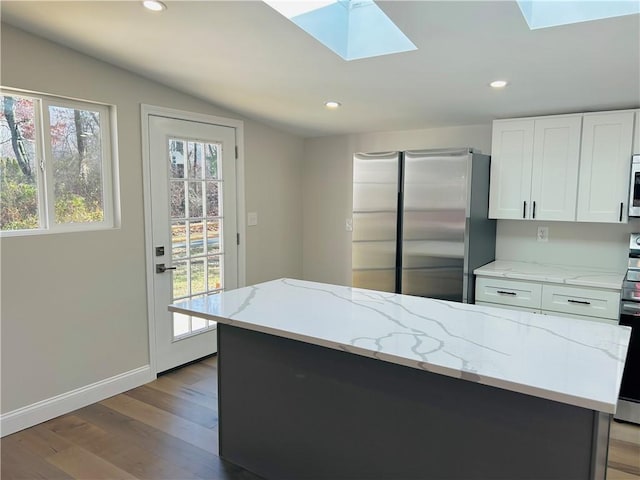 kitchen featuring white cabinets, plenty of natural light, light wood-type flooring, and stainless steel appliances