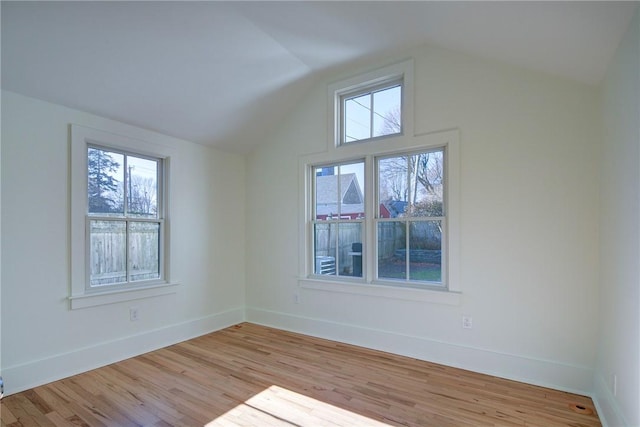 empty room with light hardwood / wood-style floors and lofted ceiling