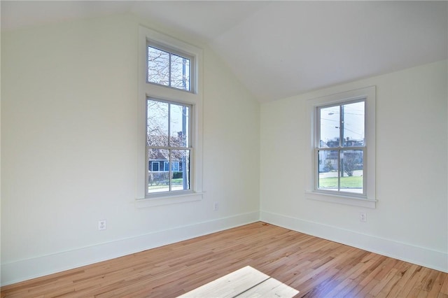 unfurnished room featuring light hardwood / wood-style flooring and lofted ceiling