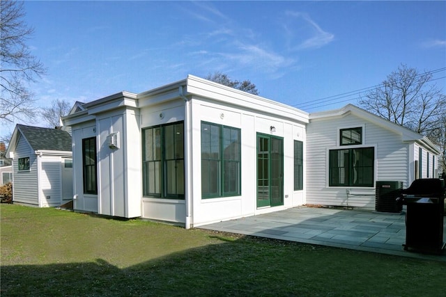 back of house with a patio area and a lawn