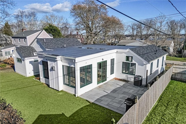 rear view of property featuring central air condition unit, a patio area, and a lawn