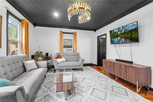 living room with hardwood / wood-style floors, plenty of natural light, crown molding, and a chandelier