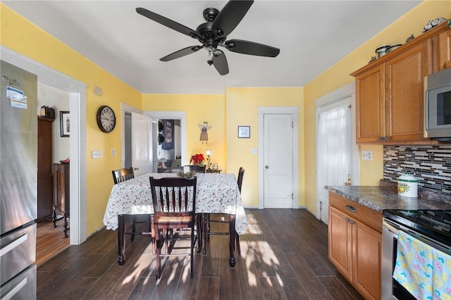 kitchen with appliances with stainless steel finishes, backsplash, dark hardwood / wood-style floors, and ceiling fan