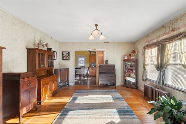 interior space featuring radiator heating unit, a notable chandelier, and light hardwood / wood-style flooring