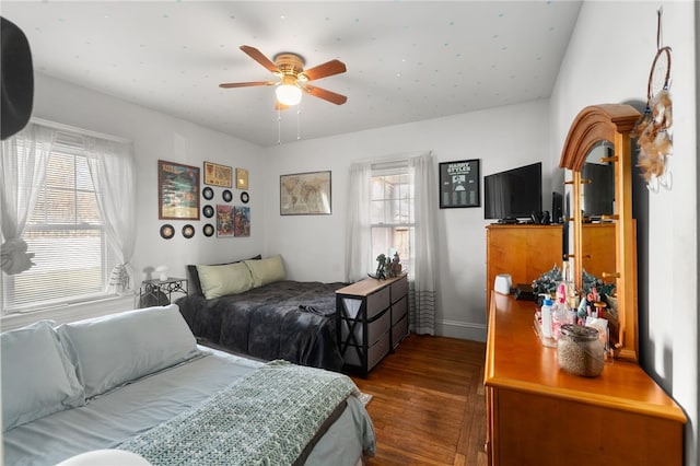 bedroom with ceiling fan, dark hardwood / wood-style floors, and multiple windows