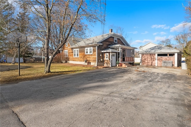 view of front of house with an outdoor structure and a front yard