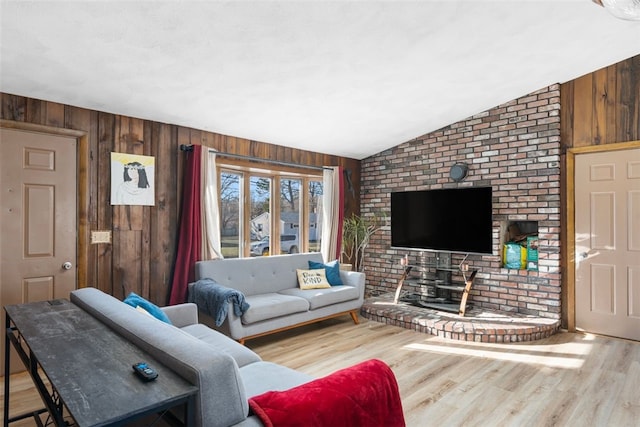 living room featuring hardwood / wood-style floors, wood walls, and lofted ceiling