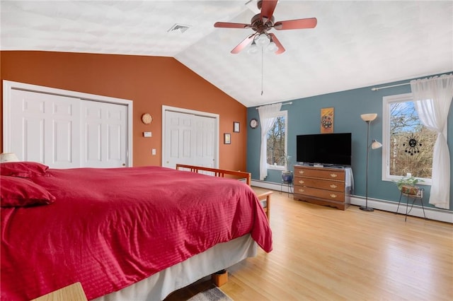 bedroom with hardwood / wood-style floors, ceiling fan, lofted ceiling, and baseboard heating