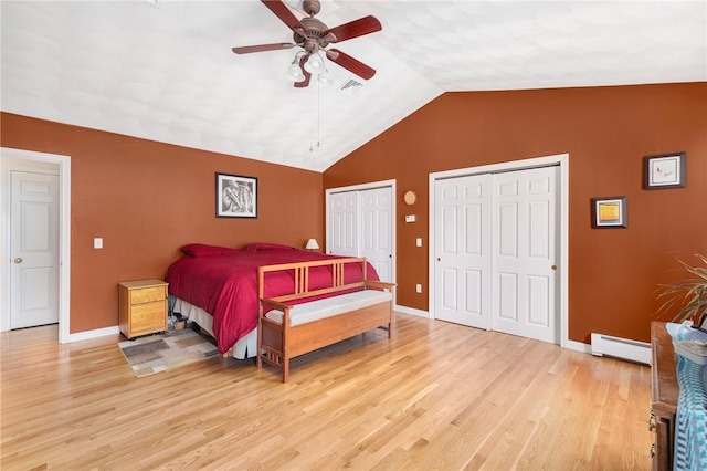 bedroom with multiple closets, ceiling fan, light hardwood / wood-style flooring, a baseboard heating unit, and lofted ceiling