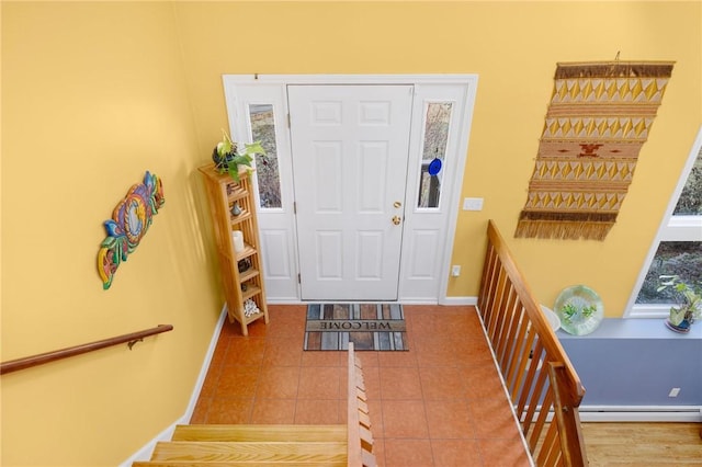 foyer featuring tile patterned flooring and a baseboard heating unit