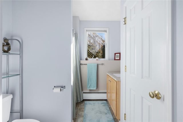 bathroom featuring toilet, vanity, and a baseboard heating unit