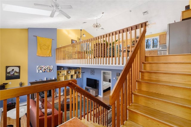 stairs featuring built in shelves and ceiling fan with notable chandelier