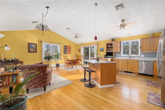 kitchen featuring a center island, light hardwood / wood-style flooring, hanging light fixtures, and appliances with stainless steel finishes