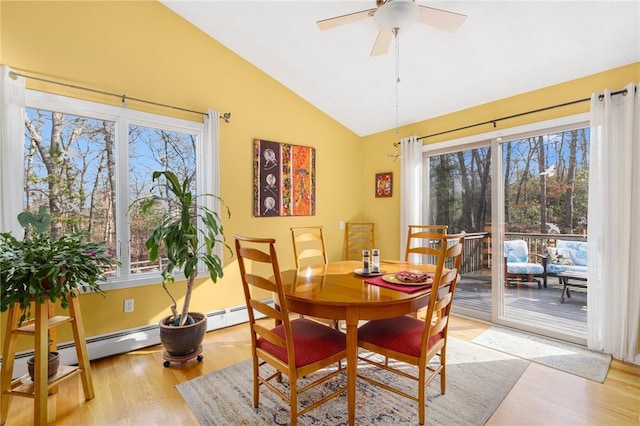 dining area with ceiling fan, a healthy amount of sunlight, light wood-type flooring, and lofted ceiling