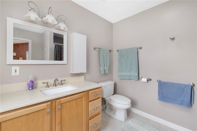 bathroom featuring tile patterned flooring, vanity, and toilet