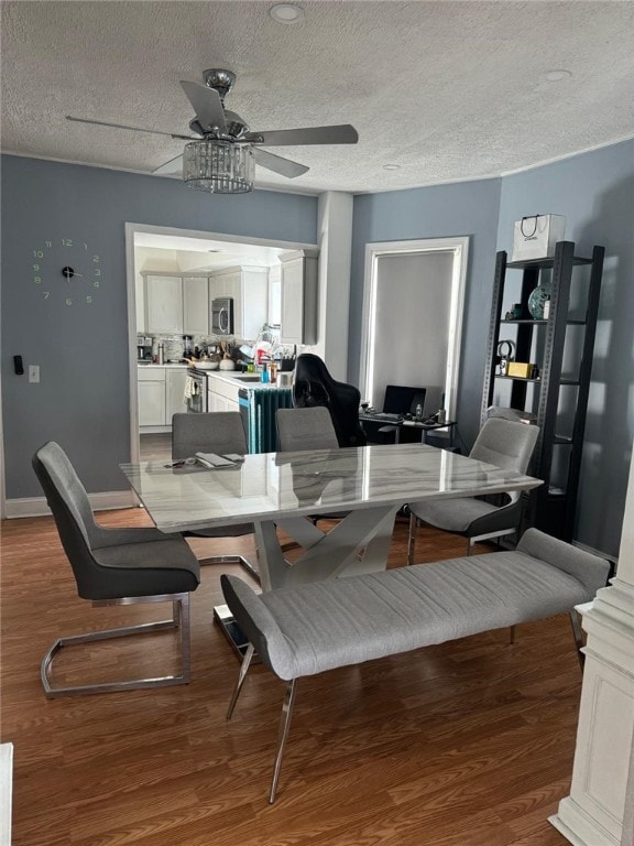 dining room with hardwood / wood-style floors, ceiling fan, and a textured ceiling