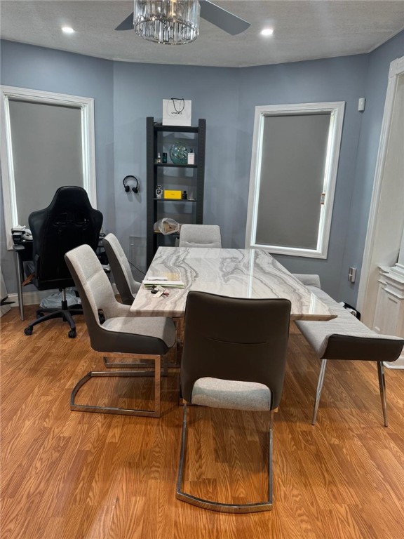 dining area with light wood-type flooring and ceiling fan