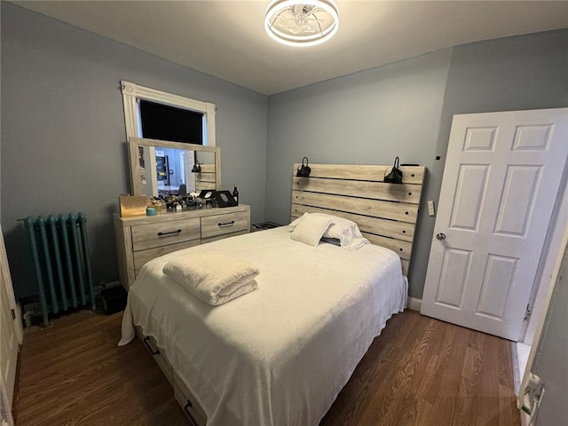 bedroom featuring radiator heating unit and dark wood-type flooring