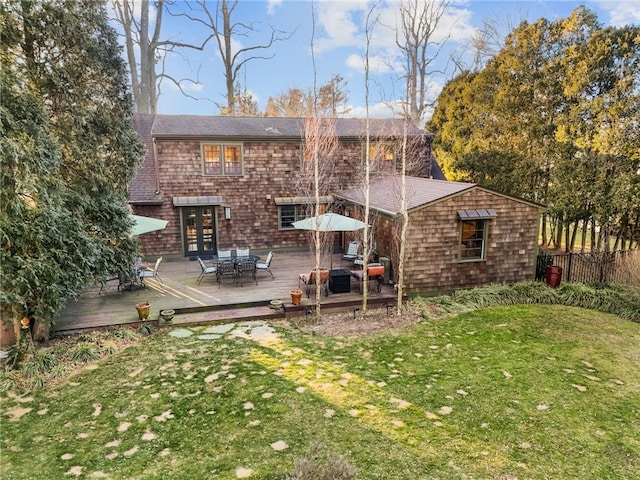 rear view of house with a deck and a yard