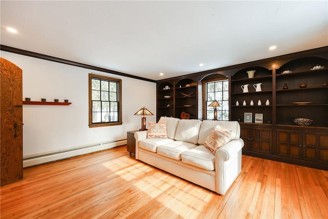 living room with light hardwood / wood-style floors, a baseboard radiator, and ornamental molding