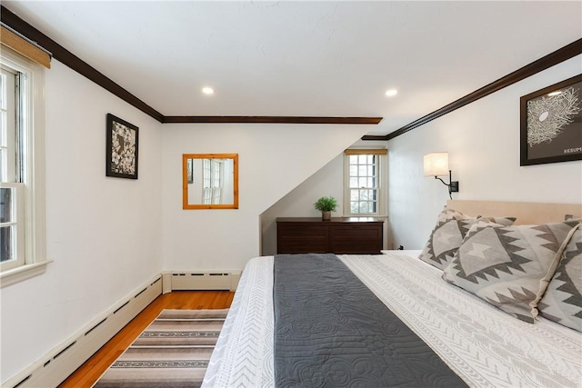 bedroom with crown molding, a baseboard radiator, and light hardwood / wood-style floors